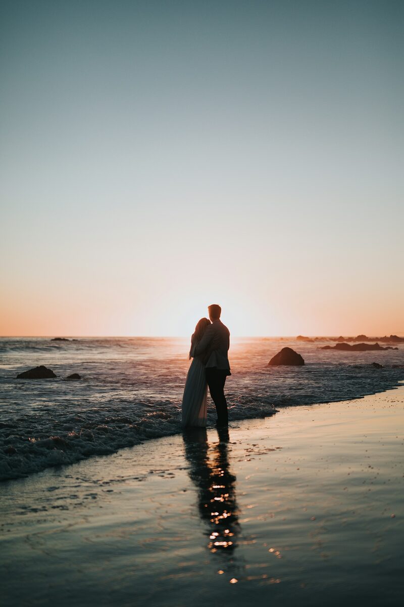 Silhouette d’un couple enlacé sur une plage au coucher du soleil — illustration pour un thème de numérologie de couple